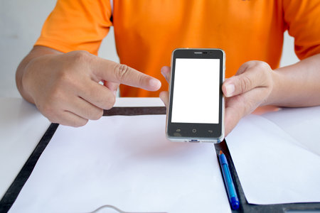 Asian man holding his blank smartphone during work in office
