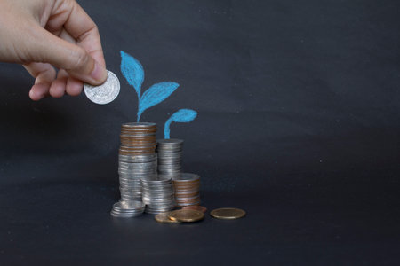 Saving money concept preset by Male hand putting money coin stack growing business.の写真素材