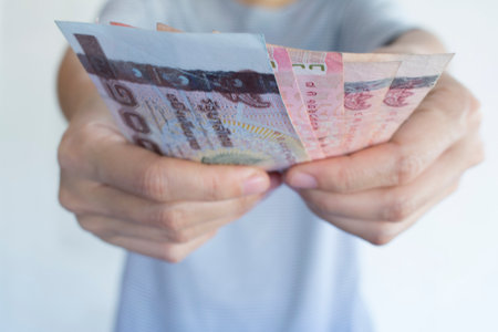 Female hands counting Thai's Bath bills or paying in cash.の写真素材