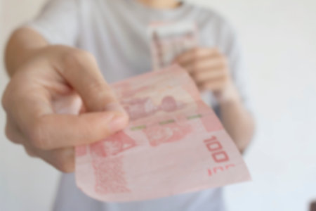Blurred of Female hands counting Thai's Bath bills or paying in cashの写真素材