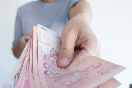 Female hands counting Thai's Bath bills or paying in cash.の写真素材
