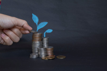 Saving money concept preset by Male hand putting money coin stack growing business.
