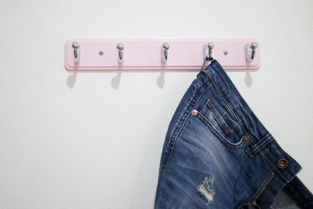 Blue Jeans hanging on white wall.の写真素材