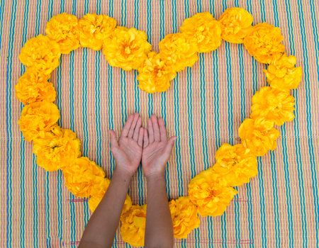 Yellow summer flowers in the form of heart with hands.