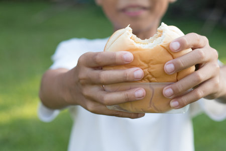 A boy holding burger and share to his friend, eating concept.の写真素材