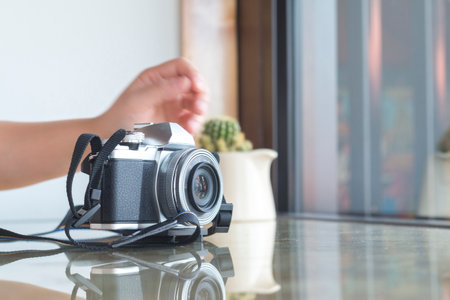 Digital camera on glass table in coffee shop.の写真素材