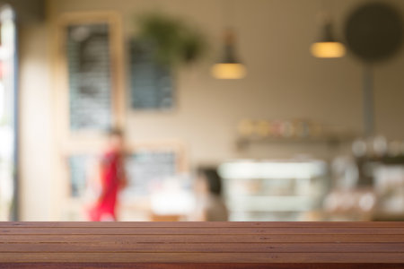 Wooden desk with Blurred of coffe's shop for abstract backgroundの写真素材