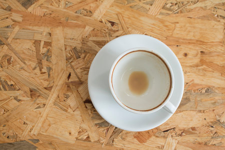 Closeup of Empty white coffee's cup after drink on wooden table.