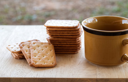 Milk cracker cookies Served with hot coffee on wooden desk ,Time break.の写真素材
