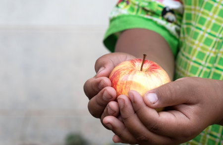 Asian boy hand holding red apple.の写真素材