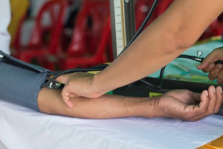 Nurse measuring blood pressure to patient.