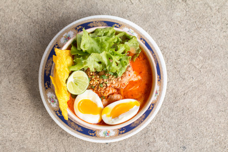 A noodle with spicy soup. Spicy lemongrass flavored flat noodles with pork and boiled egg.の写真素材