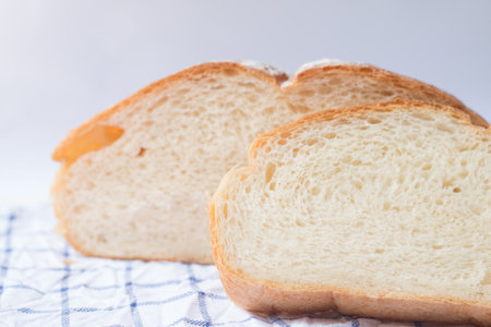 Fresh home made bread on white table background with napkin.