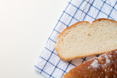 Fresh home made bread on white table background with napkin.
