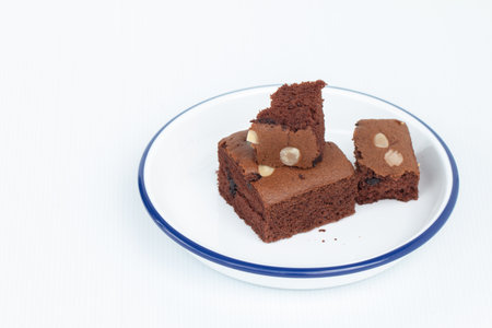 Homemade chocolate brownies topping with almond slices in white bowl.の写真素材
