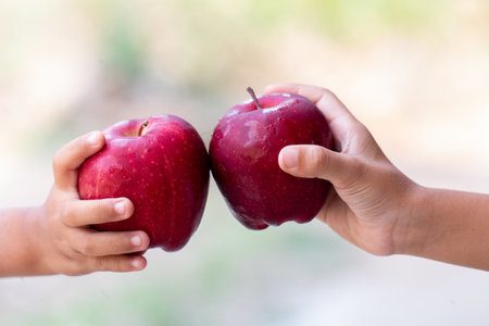 Childs is holding red Apples enjoy eat with blurred background, Healthy food for childs concept image.の写真素材
