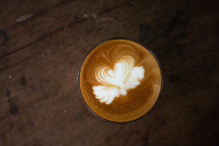 Piccolo Latte art in paper cup on wooden desk.の写真素材