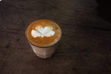 Piccolo Latte art in paper cup on wooden desk.の写真素材