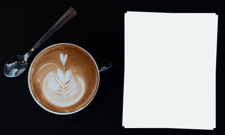 A coffee cup of Latte art  on dark wooden table.