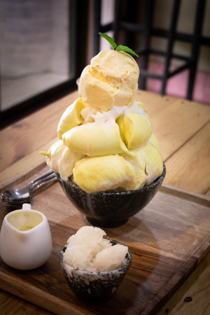 Vanilla icecream with topped Durian fruit and sticky rice on wooden desk background. Summer fruit for dessert in Thailand and Asia.の写真素材