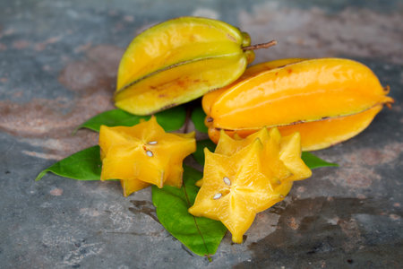 Ripe Star apple on dark wooden background or Star-fruit on dark wooden table.の写真素材