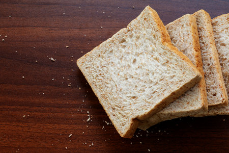Sliced toast bread on wooden table, top view, copy space.
