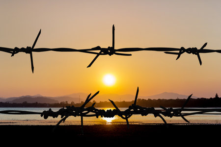Steel sharpe fence on twilight time at beach with sunsetの写真素材