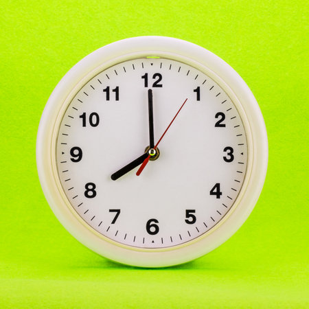 Clock at eight isolate on green background