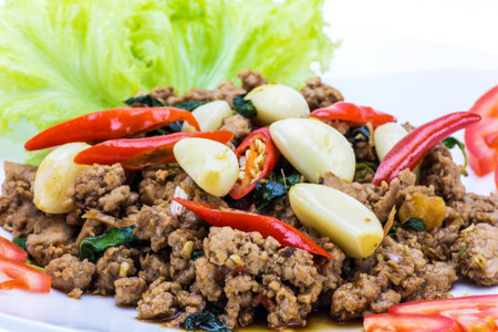 Basil pork fried with vegetable on white discの写真素材