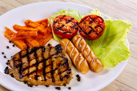 Pork steak with sausage for lunchの写真素材
