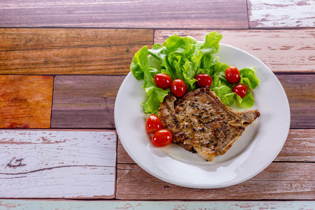 Pork steak white plate on wooden tableの写真素材