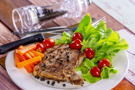 Pork steak white plate on wooden tableの写真素材
