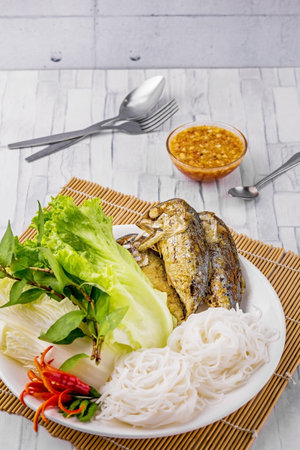 Fried mackerel with Thai rice noodles on wooden tableの写真素材