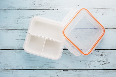 Empty white plastic food container on blue wooden tableの写真素材