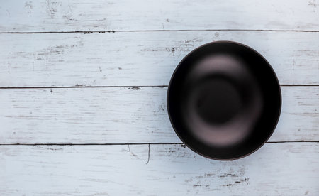 Empty black plate on blue wooden backgroundの写真素材