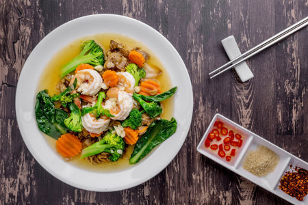 Noodles with shrimp in gravy sauce on dark wooden backgroundの写真素材
