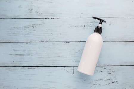 Empty shampoo white bottle on blue wooden backgroundの写真素材