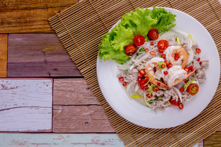 Spicy glass noodles with minced pork and shrimp on wooden backgroundの写真素材