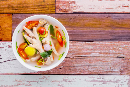 Chicken feet spicy soup tasty Thai food on wooden tableの写真素材