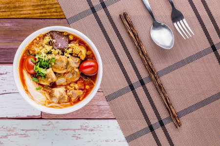 Rice vermicelli wiith northern Thai pork curry on dark wooden background