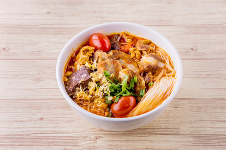 Rice vermicelli wiith northern Thai pork curry on bright wooden background