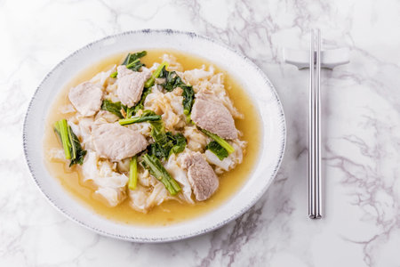 Noodles with pork in gravy sauce on bright marble backgroundの写真素材