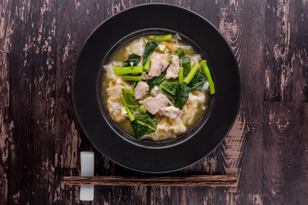 Noodles with pork in gravy sauce on dark wooden backgroundの写真素材