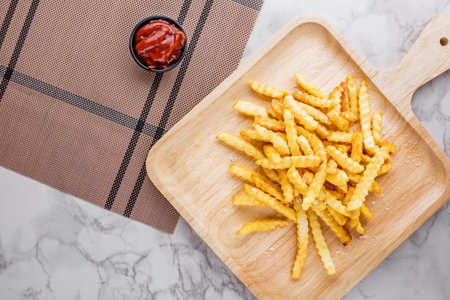 French fried in a wooden plate on marble