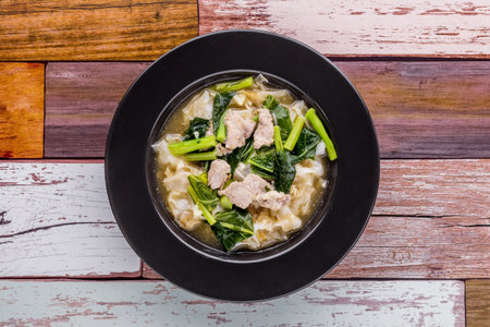 Noodles with pork in gravy sauce on dark wooden backgroundの写真素材