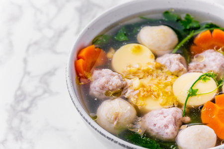 Ivy gourd clear soup with tofu and minced pork on marble background