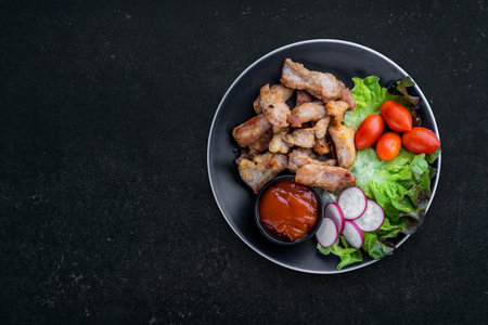 Deep fried dried pork with tomato on dark tableの写真素材