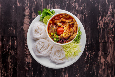 Rice vermicelli northern Thai with chicken and pok on dark wooden table background