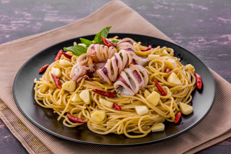 Spaghetti with spicy squid on wooden background tableの写真素材
