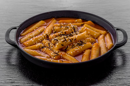 Tteokbokki Korean hot and spicy rice cake on dark table backgroundの写真素材